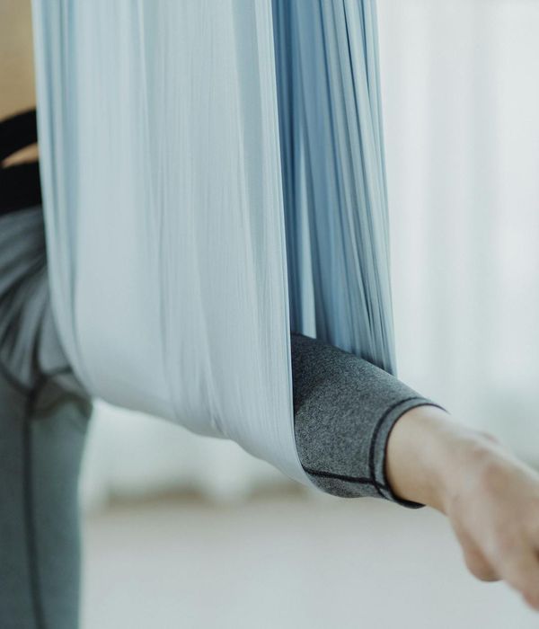 Woman performing a gentle yoga stretch in a serene studio.